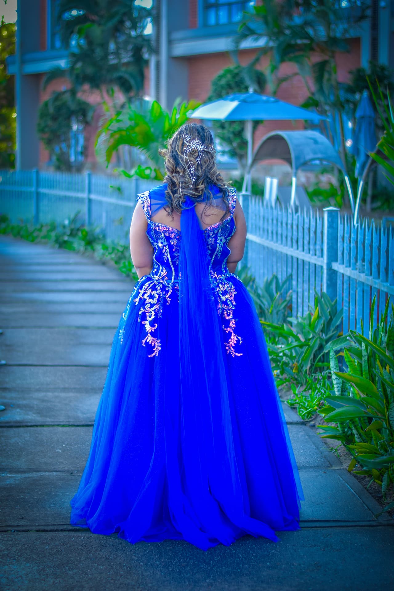 Back view of a sapphire gown with beaded detail and flowing tulle train